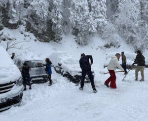 Menschen schaufeln Schnee von Autos